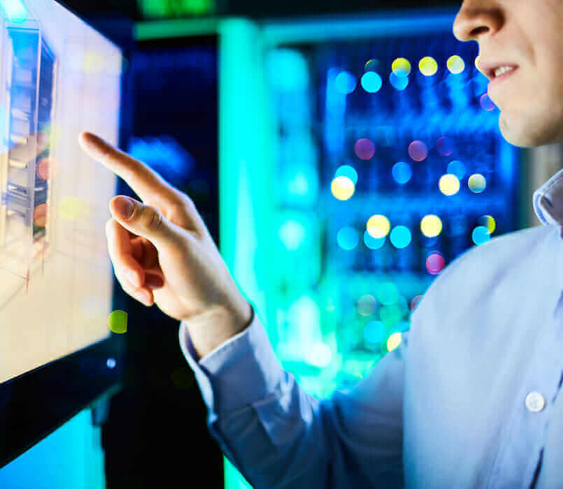 Engineer interacting with a digital touchscreen in a data center, emphasizing technology and innovation.