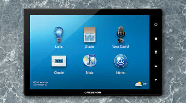 Crestron TSW-1052 touchscreen panel on marble surface, displaying smart home controls for lights, shades, climate, and more.