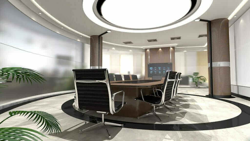 Modern conference room with sleek black chairs, round table, digital screen, and stylish lighting, ideal for business meetings.