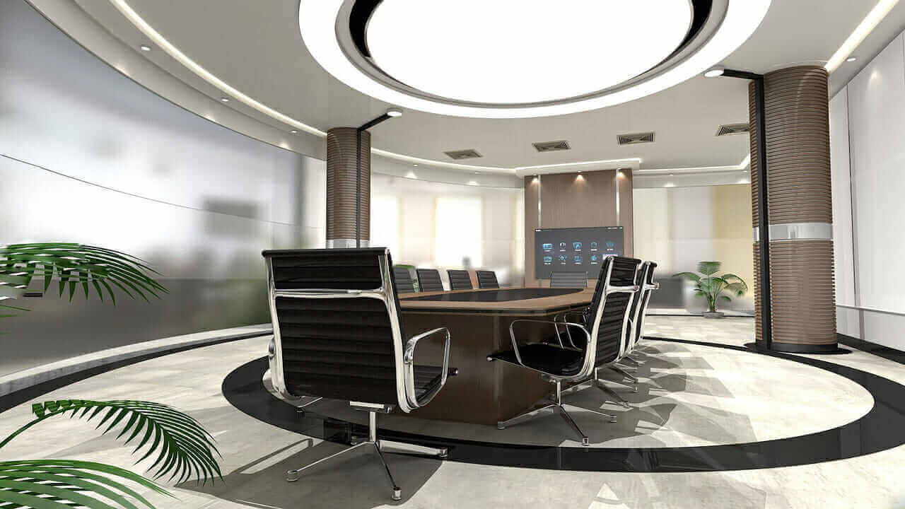 Modern conference room with sleek black chairs, round table, digital screen, and stylish lighting, ideal for business meetings.